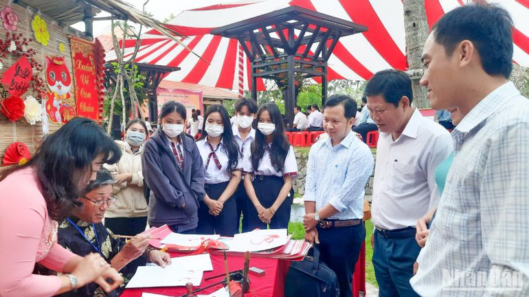 Gian trưng bày thư pháp và thầy đồ cho chữ. (Ảnh: BÁ DŨNG)