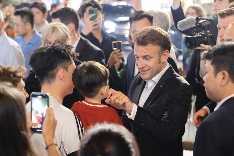 Tổng thống Pháp và Phu nhân gặp gỡ người dân trên đường tản bộ khu vực phố cổ Hà Nội. (Ảnh: TTXVN)