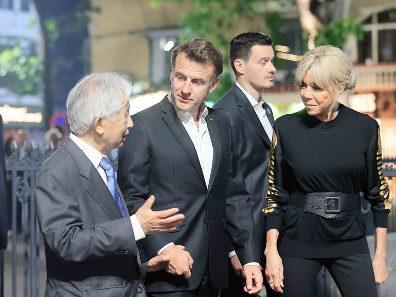 Tổng thống Pháp Emmanuel Macron và Phu nhân nghe giới thiệu về nét văn hóa phố cổ Hà Nội. (Ảnh: TTXVN)