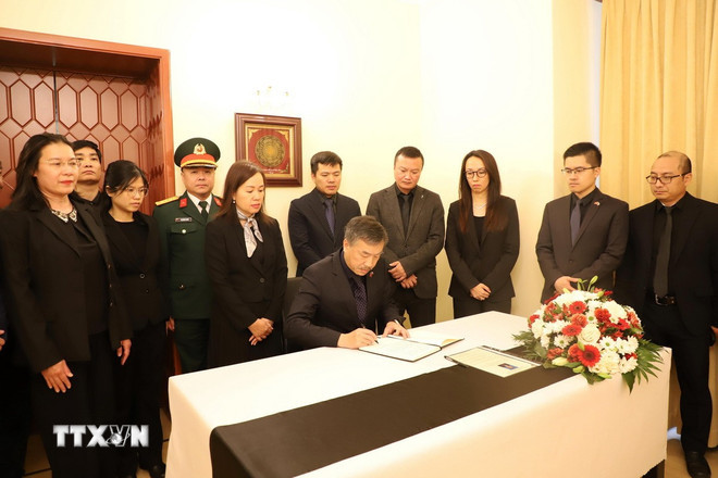 Đại sứ Dương Hoài Nam mở đầu nghi thức ghi sổ tang nguyên Chủ tịch nước Trần Đức Lương. (Ảnh: TTXVN)