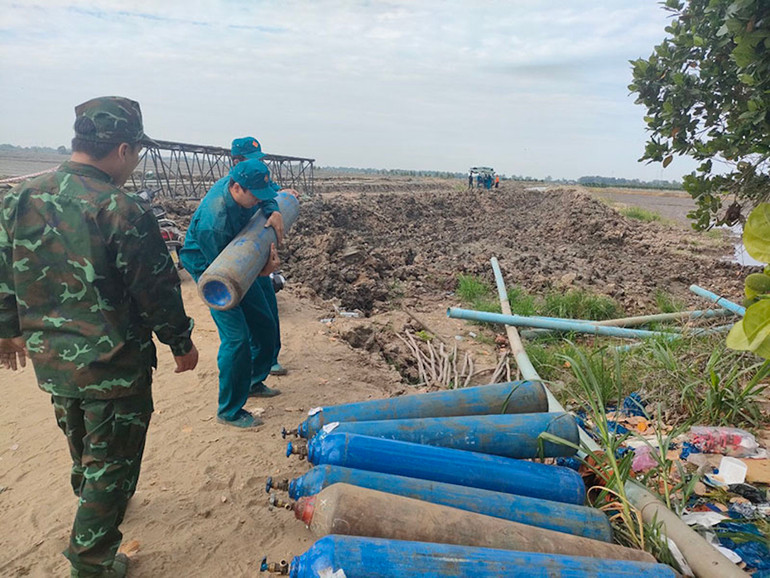 Hàng chục bình oxy được đưa đến hiện trường để giải cứu cháu bé. (Ảnh: HỮU NGHĨA)
