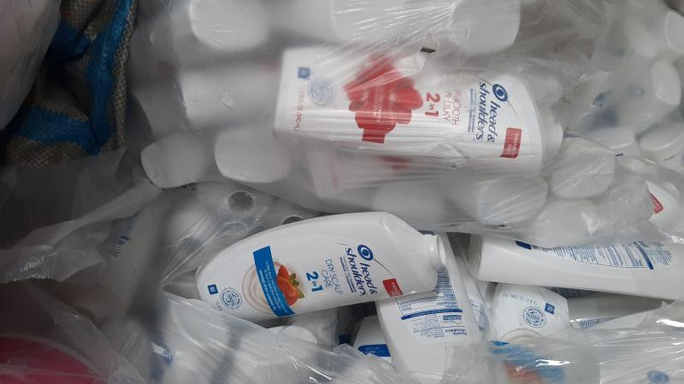 Các hộp đựng dầu gội giả thương hiệu nổi tiếng tại hiện trường. (Ảnh: Tổng cục Quản lý thị trường).