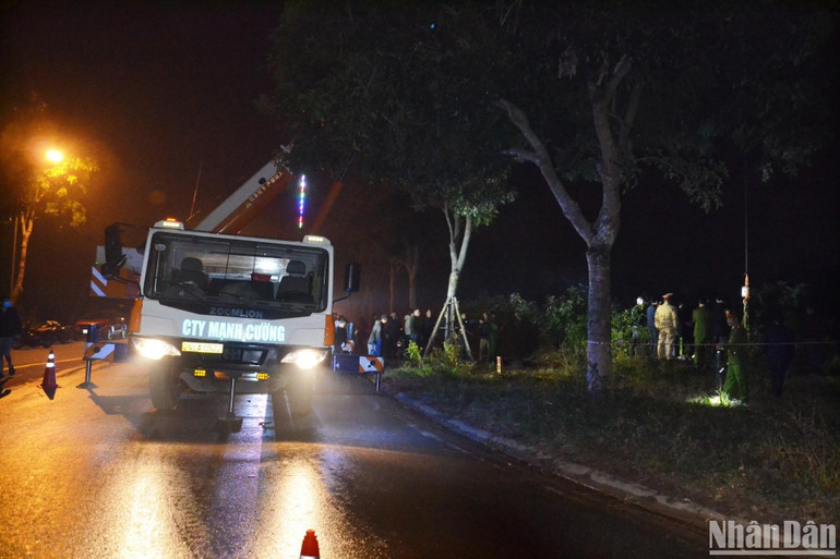 Lực lượng chức năng đang cẩu kéo chiếc xe lên mặt đường.
