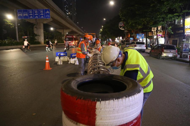 Hàng chục công nhân thực hiện lắp đặt dải phân cách cứng trên đường Nguyễn Trãi tối 5/8.