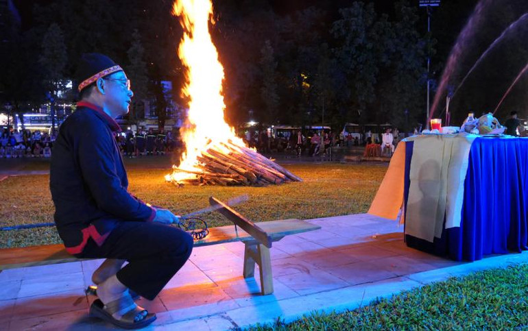 Ngọn lửa bùng lên, nghệ nhân Sìn Văn Dương, xã Tân Bắc, huyện Quang Bình bày lễ, thắp hương, miệng đọc bài cúng, tay trái cầm que tre, tay phải cầm vòng bạc gõ đều trên đàn Pàn dơ.