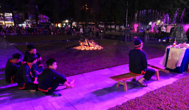 Khi thầy làm lễ, những chàng trai tham gia nhảy lửa ngồi đợi quanh đống lửa.