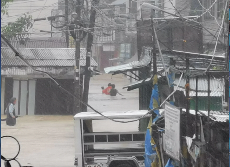 Người dân lội qua dòng nước lũ do bão nhiệt đới Nalgae ở Boac, tỉnh Marinduque, Philippines, ngày 29/10. (Ảnh: Reuters)