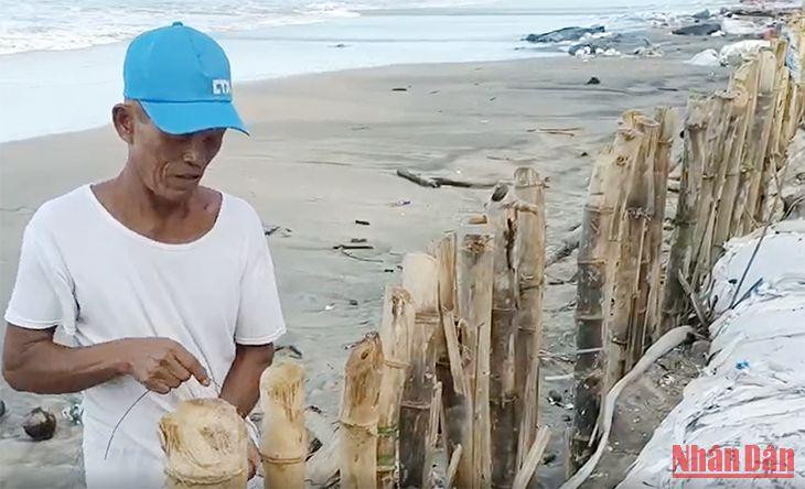 Người dân gia cố bờ kè tạm để ngăn chặn sạt lở.