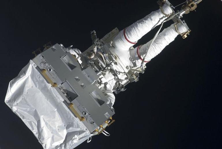 Phi hành gia Dave Wolf vận chuyển thiết bị tới Bệ chứa bên ngoài của trạm để lưu trữ lâu dài vào ngày 20/7/2009. (Ảnh: REUTERS/NASA)