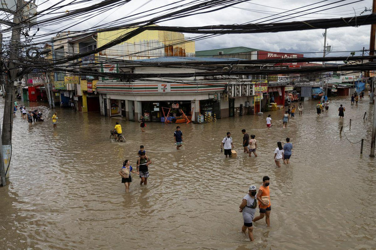 Người dân lội qua những con phố ngập lụt ở Imus, tỉnh Cavite, Philippines, ngày 30/10. (Ảnh: Reuters)