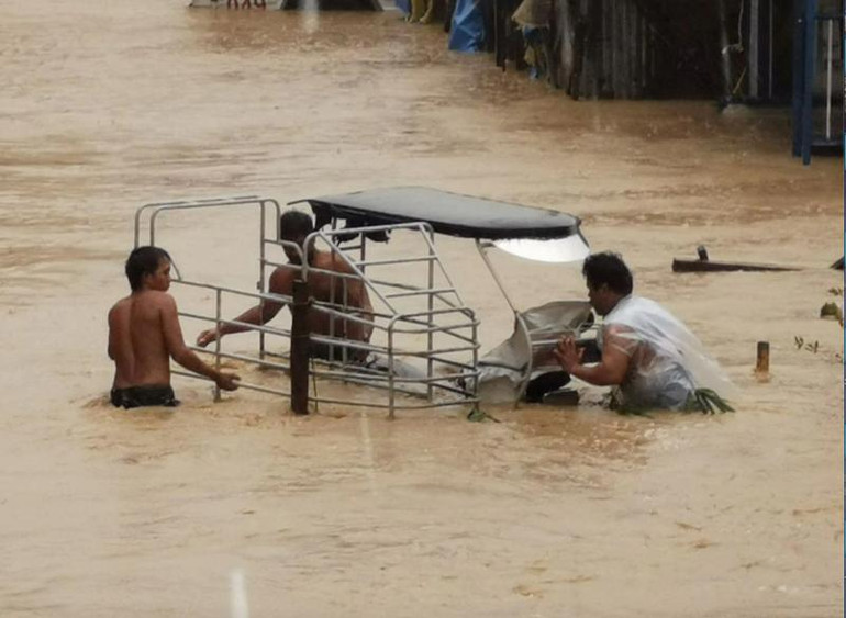 Người dân lội qua nước lũ ở Boac, Marinduque, Philippines, ngày 29/10. (Ảnh: Reuters)