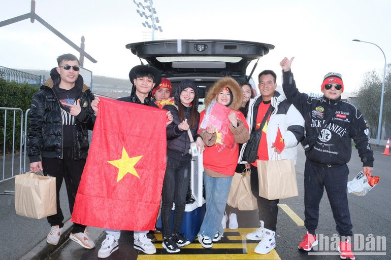 Đoàn của chị Thái quê ở Hà Nội, là những người đến sớm nhất từ Auckland. Họ chuẩn bị sẵn sàng cờ Tổ quốc cho khoảng 20 người. (Ảnh: ĐỖ ĐẠT)