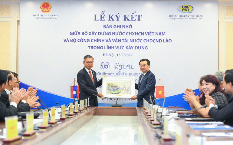 Bộ trưởng Công chính và Vận tải Lào Viengsavath Siphandone (bên trái) tặng quà lưu niệm Bộ Xây dựng Việt Nam. (Ảnh: Thành Đạt)