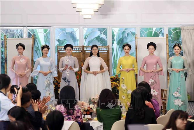 Trình diễn áo dài – trang phục truyền thống biểu tượng cho nét đẹp của phụ nữ Việt Nam tại buổi gặp mặt. (Ảnh: TTXVN)