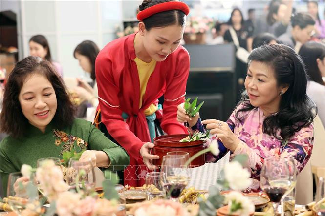 Bà Ngô Phương Ly, Phu nhân Tổng Bí thư, Chủ tịch nước Tô Lâm và các đại biểu trải nghiệm têm trầu cánh phượng. (Ảnh: TTXVN)