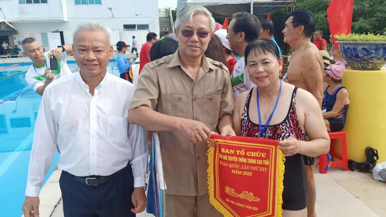 Phó Vụ trưởng Vụ Thể dục, thể thao quần chúng Phạm Đông Anh trao cờ lưu niệm cho đại diện đơn vị tham dự Giải bơi trung, cao tuổi.