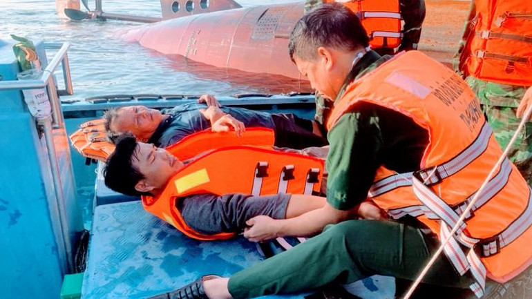 Lực lượng cứu nạn chăm sóc y tế cho 2 thuyền viên được cứu trên biển.
