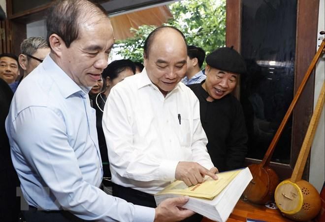 Chủ tịch nước Nguyễn Xuân Phúc thăm Nghệ nhân Ưu tú Ma Văn Đức ở phường Tân Hà, thành phố Tuyên Quang. (Ảnh: TTXVN)