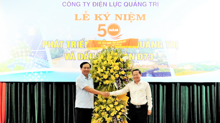 Phó Bí thư Tỉnh ủy, Chủ tịch Ủy ban nhân dân tỉnh Quảng Trị Võ Văn Hưng (bên trái) tặng hoa chúc mừng Công ty Điện lực Quảng Trị. (Ảnh: LÂM QUANG HUY)