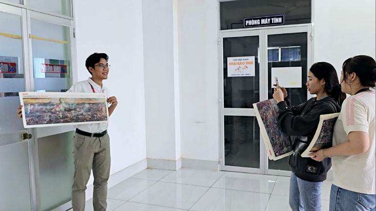 Chụp ảnh lưu niệm với tranh panorama Chiến thắng Điện Biên Phủ tại trụ sở Cơ quan Thường trực Báo Nhân Dân Cần Thơ.