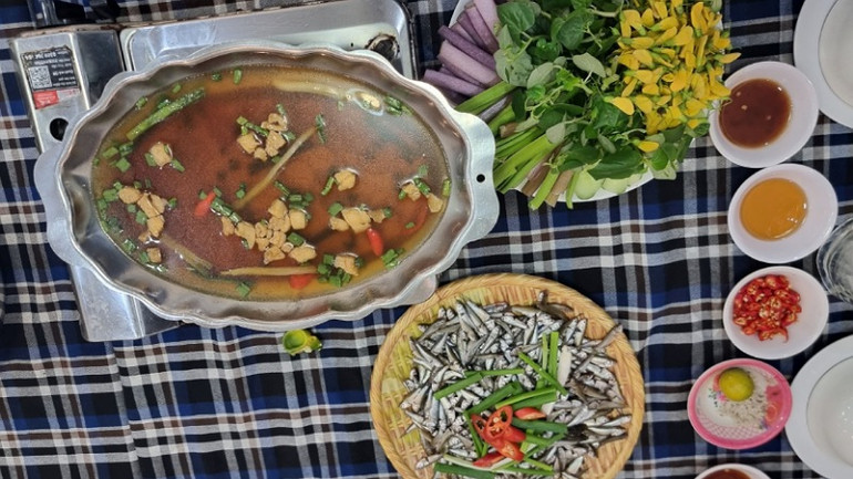 Cá linh non kho lạt ăn kèm bông điên điển là món đặc sản mùa nước nổi miền Tây.