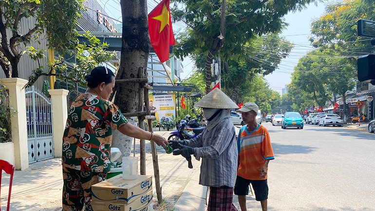 Cô Cúc tặng nước cho mọi người cần.