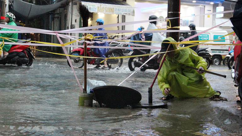 Nắp cống thoát nước mở, người dân tại kiệt đã túc trực để theo dõi.