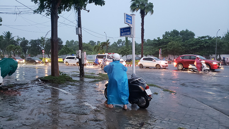 Người dân lựa chọn dắt bộ xe để qua khu vực nước ngập.