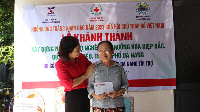 Bà Nguyễn Thị Đạt bên ngôi nhà mới hoàn thành.