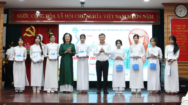 Tặng quà nữ sinh mồ côi vượt khó có thành tích học tập tốt.