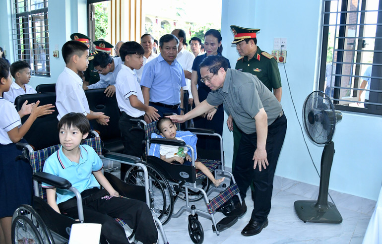 Thủ tướng Phạm Minh Chính ân cần thăm hỏi một cháu khuyết đang được nuôi dạy ở Trung tâm.