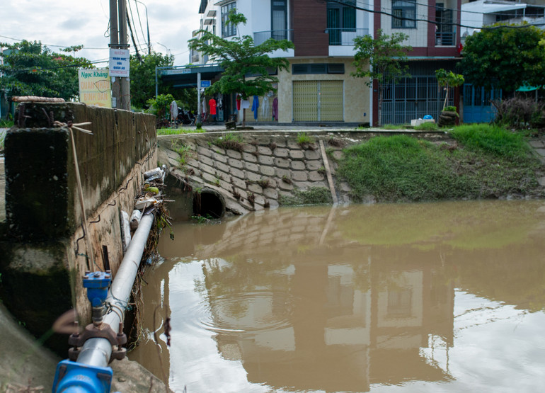 Mưa lớn kéo dài khiến mực nước kênh dâng lên, làm rác mắc lại trên đường cống bên dưới thành cầu đường Nguyễn Khắc Nhu.
