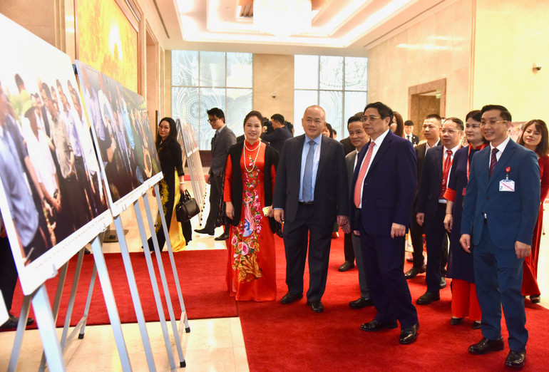 Thủ tướng Phạm Minh Chính và các đại biểu tham quan triển lãm ảnh về kinh tế hợp tác xã tại diễn đàn.