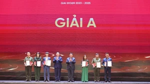 Các đồng chí Nguyễn Trọng Nghĩa và Nguyễn Xuân Thắng trao giải A cho các tác giả.