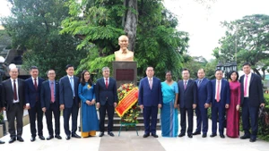 Trưởng Ban Tuyên giáo và Dân vận Trung ương Nguyễn Trọng Nghĩa cùng các thành viên trong đoàn và đại diện Thư viện công cộng Colombo chụp ảnh lưu niệm bên cạnh tượng đài Bác Hồ ở thủ đô Colombo. (Ảnh: TTXVN)