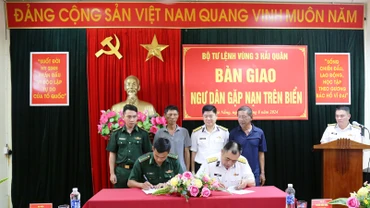 Đại diện Bộ Tư lệnh Vùng 3 Hải quân và Đồn Biên phòng Sơn Trà ký giao, nhận hai ngư dân gặp nạn.