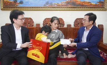 Giám đốc Sở Giáo dục-Đào tạo Quảng Bình Đặng Ngọc Tuấn (bên phải) thăm, tặng quà cô Nguyễn Thị Huế, giáo viên Trường mầm non Nam Lý, thành phố Đồng Hới. Cô Huế bị bệnh nặng, lại phải nuôi con nhỏ bị mù bẩm sinh. 