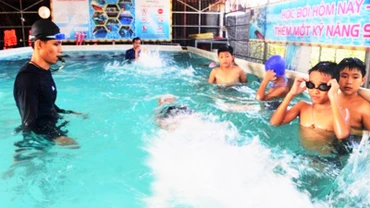 Giáo viên ở Lệ Thủy, Quảng Bình dạy bơi cho học sinh. (Ảnh: Hương Giang)