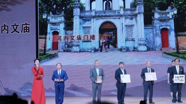 Ông Nguyễn Văn Tú, Phó Giám đốc Trung tâm hoạt động văn hóa khoa học Văn Miếu-Quốc Tử Giám (thứ hai bên trái) giới thiệu mô hình Văn Miếu-Quốc Tử Giám, Hà Nội.