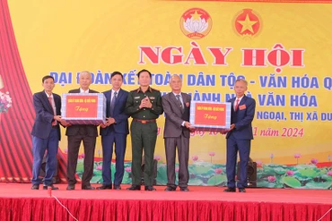 Đại tướng Nguyễn Tân Cương tặng quà cho Đảng ủy, UBND xã Tiên Ngoại và thôn Trung Liêu. 