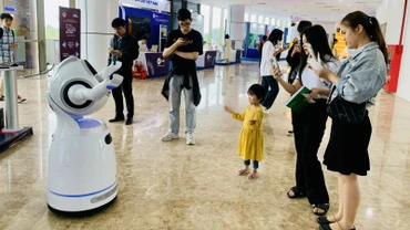 Người dân bị thu hút bởi rô-bốt tại một sự kiện về đổi mới sáng tạo Việt Nam. (Ảnh: HNV)