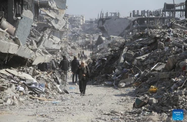 Người dân Palestine trên một con phố có những tòa nhà bị phá hủy tại trại tị nạn Jabalia ở phía bắc Dải Gaza, vào ngày 29/1/2025. Ảnh: Tân Hoa xã.