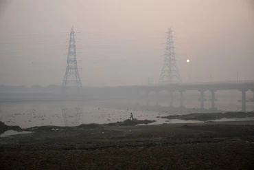 Một người đàn ông đi bộ trên bờ sông Yamuna vào một buổi sáng sương mù ở New Delhi, Ấn Độ. (Ảnh: Reuters)