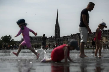Người dân giải nhiệt tránh nóng tại khu vực đài phun nước ở Bordeaux, Pháp, ngày 18/5/2022. (Ảnh: AFP/TTXVN)