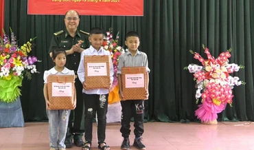 Cán bộ chiến sĩ đồn biên Phòng Chi Lăng, Lộc Bình (Lạng Sơn) tặng sách vở cho các em học sinh là con nuôi đồn biên phòng.