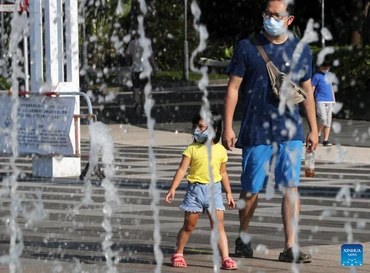 Người dân đi ngang qua đài phun nước vào một ngày hè nóng nực ở Hong Kong, Trung Quốc. Ảnh: Tân Hoa xã