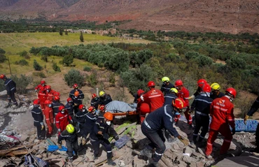 Các nhân viên cứu hộ đang tìm kiếm người mất tích. Ảnh: Reuters.