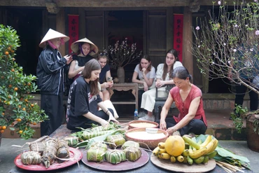 Các vị khách quốc tế trải nghiệm gói bánh chưng.