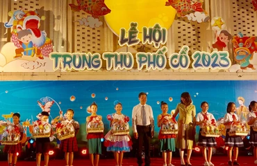 Lãnh đạo Uỷ ban nhân dân quận Hoàn Kiếm trao quà cho các em học sinh.