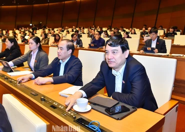 Các đại biểu Quốc hội bấm nút biểu quyết thông qua Nghị quyết về việc tiếp tục thực hiện một số chính sách trong phòng, chống dịch Covid-19 và cho phép tiếp tục sử dụng giấy đăng ký lưu hành thuốc, nguyên liệu làm thuốc hết thời hạn hiệu lực từ ngày 1/1/2023 mà chưa kịp gia hạn theo quy định của Luật Dược. (Ảnh: THỦY NGUYÊN)
